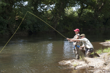 Fly fishing gillie instructing a pupil River Lyd Devon UK