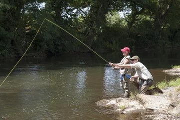 Stof per meter Fly fishing gillie instructing a pupil River Lyd Devon UK © petert2