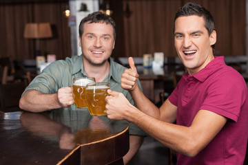 Good day to meet friend. Two happy friends holding the mugs with