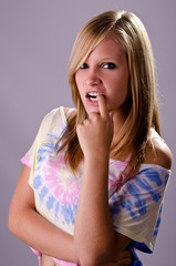 Young blonde model posing with finger hooked in mouth