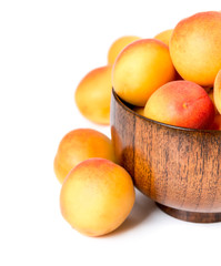 Ripe apricots in a wooden bowl