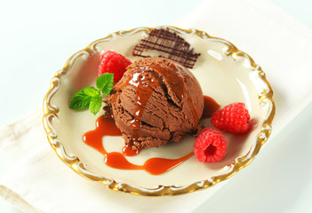 Chocolate brownie ice cream with caramel sauce and raspberries
