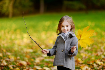 Adorable girl having fun on autumn day