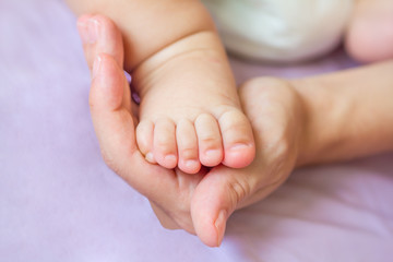 Obraz na płótnie Canvas Newborn stóp dziecka w ręce matki