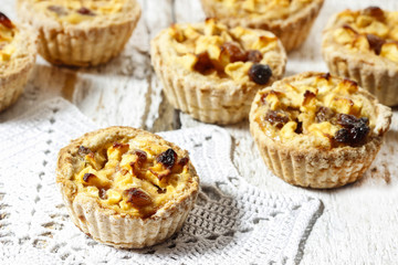 Homemade tart with dried fruits and fresh apples on white wooden