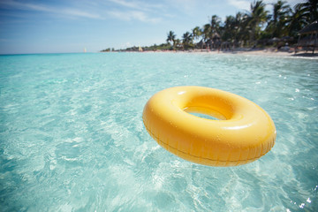 floating ring on blue clear sea with beach, shallow dof
