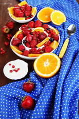 Useful fruit salad in plates on wooden table close-up