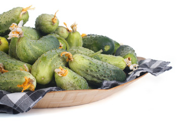 Fresh cucumbers on a beautiful wooden plate with a napkin