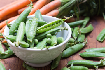 Pea pods in a bowl with carrots