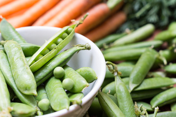Pea pods in a bowl with carrots