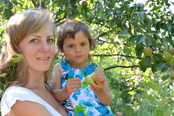 Portrait of the young woman with the child about a pear tree