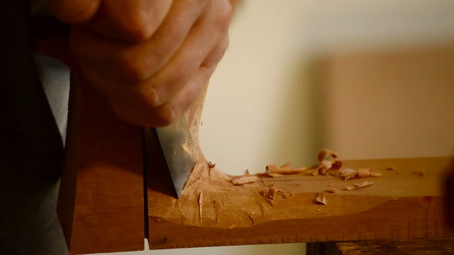 Luthier with chisel making a guitar mastil, close up