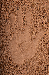 Hand in sand on beach
