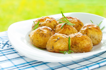 Baked potatoes with rosemary on white plate