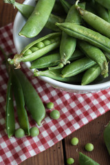 Pea pods in a bowl on wooden Table