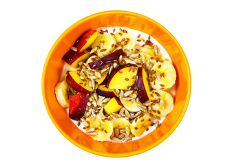 Orange plate with peach, banana, seeds and yougurt
