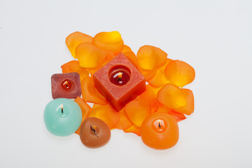 Spilt petals of the orange-rose around the aromatic candle