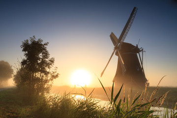 Dutch windmill at a foggy sunrise