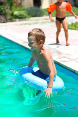 Naklejka premium Preschool boy are jumping to the swimming pool