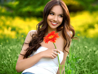 Naklejka premium Beautiful Woman With Gerbera Flower Enjoying Nature.