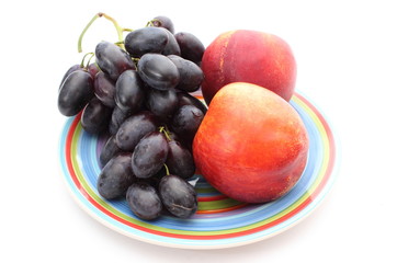 Fruits on colorful plate isolated on white background