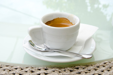 White espresso cup standing on the table of the street cafe