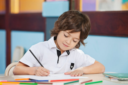 Boy With Sketch Pen Drawing In Kindergarten