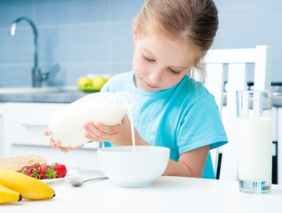 little girl pouring milk