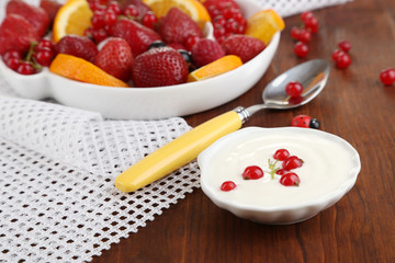 Useful fruit salad in plate on wooden table close-up