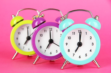 Colorful alarm clock on pink background