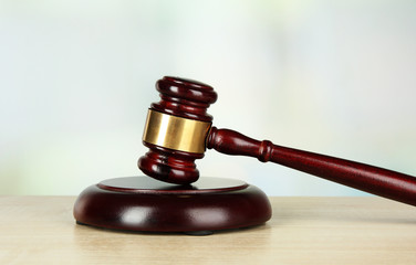 Judges gavel on wooden table on light background