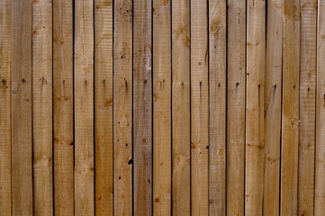 Vertical wooden fence made of old boards.