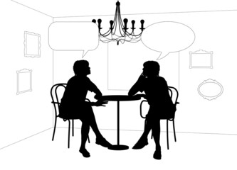 two women speaking at the table in cafe
