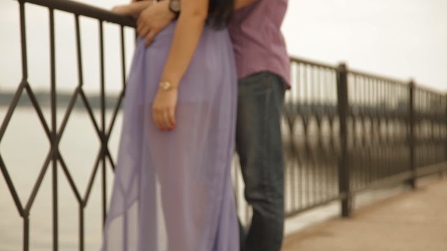 White couple enjoy each other near the fence and river