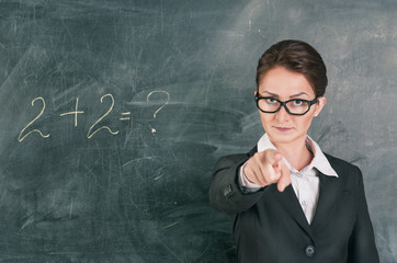 Woman teacher teaching maths and pointing on someone
