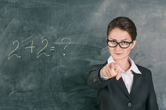 Woman teacher teaching maths and pointing on someone