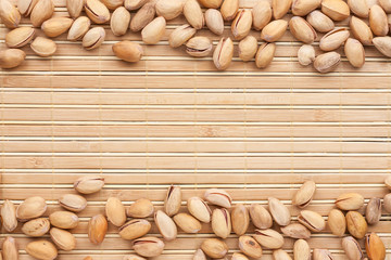 Pistachios  lies on the a bamboo mat
