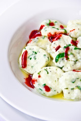 Portion of good boiled fruit dumplings in berry sauce.