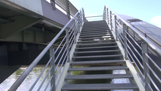 walking on big metallic bridge staircase
