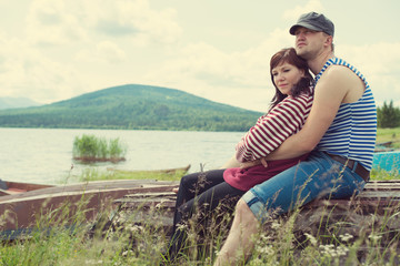 Young couple dating on the shore of picturesque mountain lake