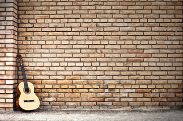 Fototapeta na wymiar gitara klasyczna i ceglany mur