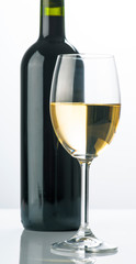 bottle of red wine is seen through a glass of white wine