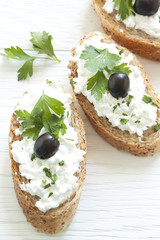 Crostini with cottage cheese, parsley and olive