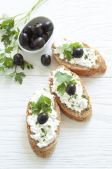 Crostini with cottage cheese, parsley and olive
