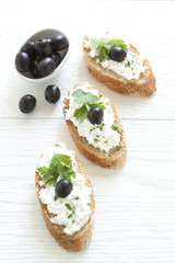 Crostini with cottage cheese, parsley and olive