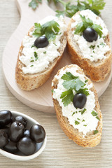 Crostini with cottage cheese, parsley and olive