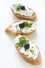 Crostini with cottage cheese, parsley and olive