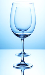 Empty wine glasses arranged on blue background