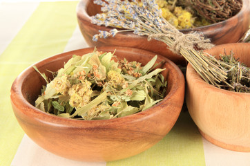 Medicinal Herbs in wooden bowls on striped tablecloth