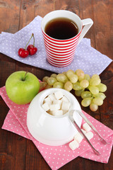 Refined sugar in white sugar bowl on wooden background